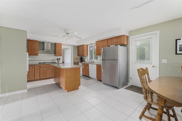 218 Burnt Cedar Dr, North Kingstown, RI 02852 - kitchen with stainless steel appliances, wall chimney exhaust hood, a center island, and brown cabinetry
