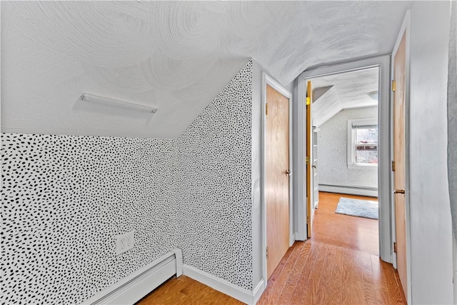 hallway featuring light wood-style flooring and a baseboard radiator