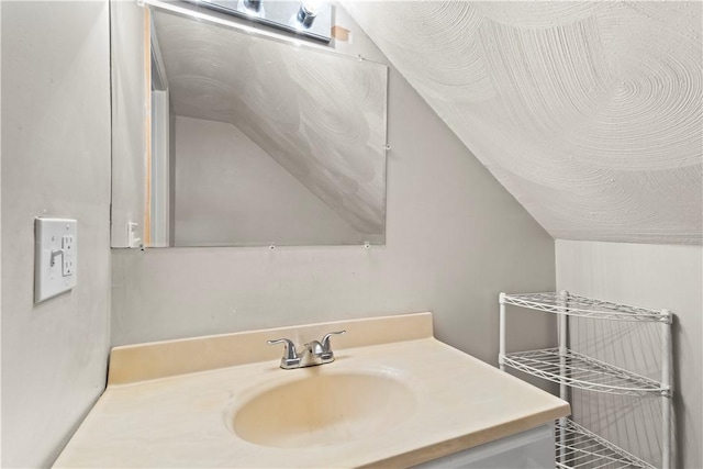 bathroom featuring vanity and lofted ceiling