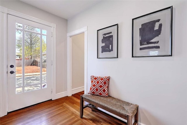 doorway featuring wood finished floors and baseboards