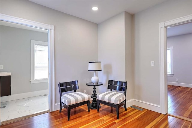 living area with hardwood / wood-style flooring, baseboards, and recessed lighting