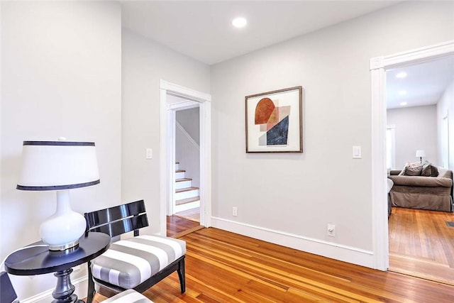 sitting room featuring hardwood / wood-style flooring, stairway, recessed lighting, and baseboards