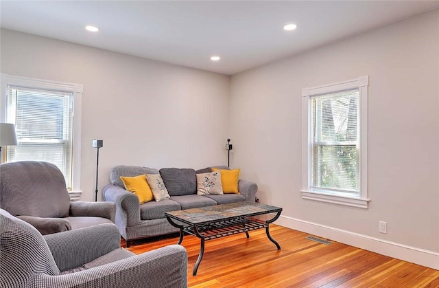 living room with light wood-type flooring, baseboards, and recessed lighting