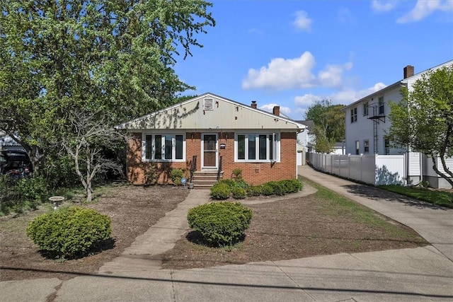 bungalow with fence and brick siding