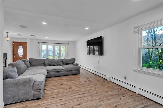 living room featuring healthy amount of natural light, light wood-type flooring, and recessed lighting