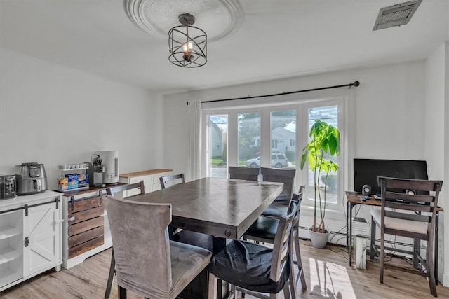 dining room featuring light wood-style floors and a chandelier