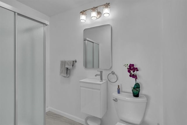 full bath featuring a sink, a shower stall, toilet, and marble finish floors