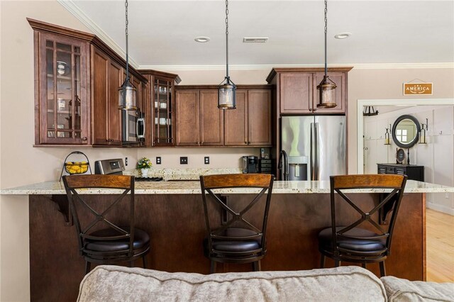 16 Kimberly Ct, North Kingstown, RI 02852 - kitchen with appliances with stainless steel finishes, a kitchen bar, crown molding, hanging light fixtures, and glass insert cabinets