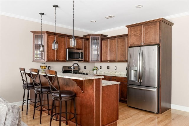 16 Kimberly Ct, North Kingstown, RI 02852 - kitchen featuring appliances with stainless steel finishes, a breakfast bar area, glass insert cabinets, light wood-style floors, and a peninsula