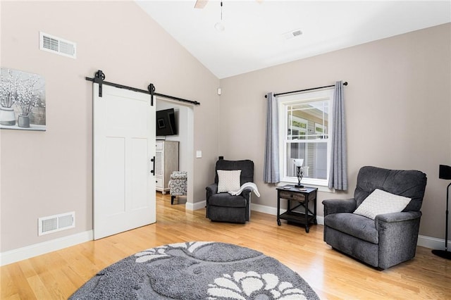 16 Kimberly Ct, North Kingstown, RI 02852 - living area featuring a barn door, wood finished floors, high vaulted ceiling, and baseboards