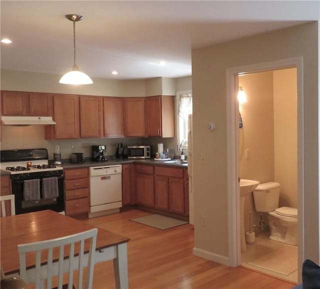 94 Barton St, Pawtucket, RI 02860 - kitchen featuring white dishwasher, range with gas cooktop, under cabinet range hood, light wood-style flooring, and stainless steel microwave