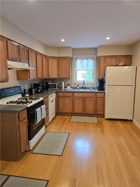 94 Barton St, Pawtucket, RI 02860 - kitchen with white appliances, under cabinet range hood, a sink, brown cabinetry, and recessed lighting