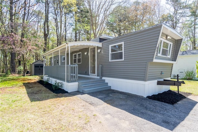67 Linda Dr, Coventry, RI 02816 - manufactured / mobile home with a storage unit, an outbuilding, covered porch, and a front yard