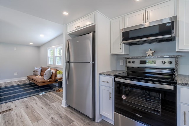 67 Linda Dr, Coventry, RI 02816 - kitchen with stainless steel appliances, light wood-type flooring, vaulted ceiling, white cabinetry, and stone counters
