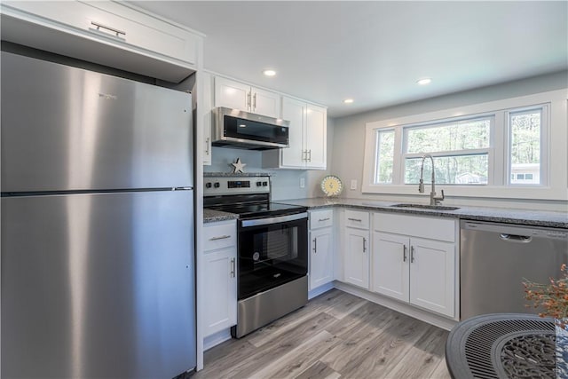 67 Linda Dr, Coventry, RI 02816 - kitchen with appliances with stainless steel finishes, a sink, stone countertops, white cabinetry, and light wood-style flooring