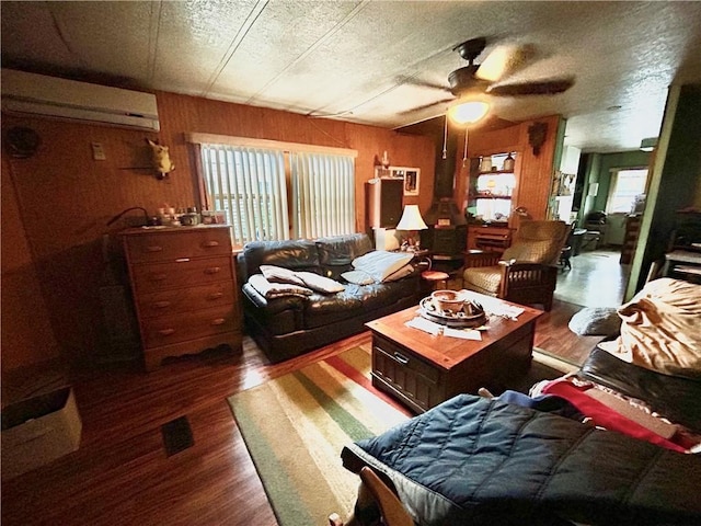 245 Manton St, Pawtucket, RI 02861 - living room with an AC wall unit, dark wood-type flooring, ceiling fan, and wooden walls