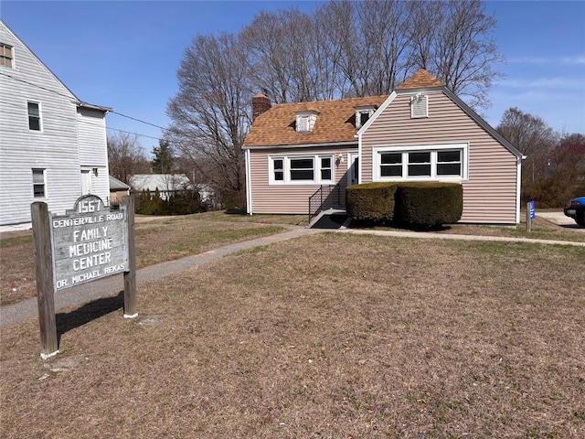 view of front of house with a chimney and a front yard