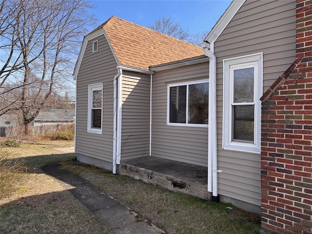 view of side of property featuring roof with shingles