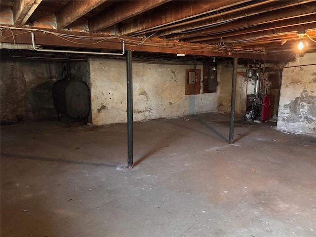 unfinished below grade area with heating fuel, a heating unit, and electric panel