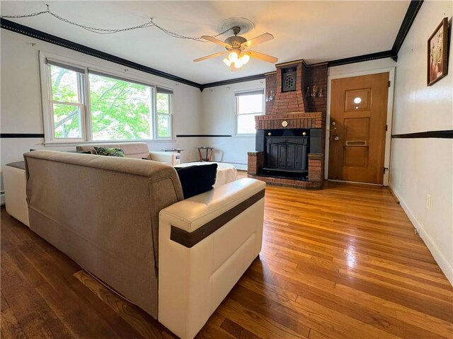 74 Lubec St, Providence, RI 02904 - living area featuring ornamental molding, a brick fireplace, hardwood / wood-style floors, ceiling fan, and baseboards