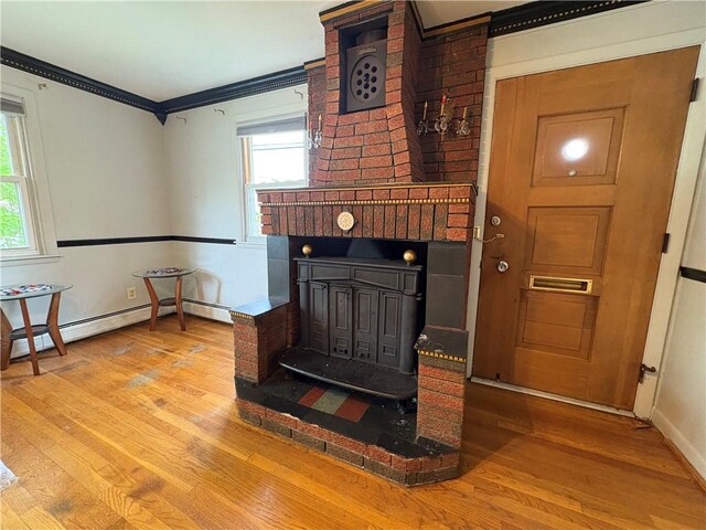 74 Lubec St, Providence, RI 02904 - detailed view of wood finished floors, crown molding, baseboards, a wood stove, and baseboard heating