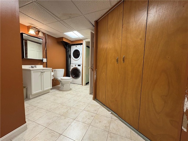 74 Lubec St, Providence, RI 02904 - bathroom with estacked washer and dryer, toilet, tile patterned floors, vanity, and a drop ceiling