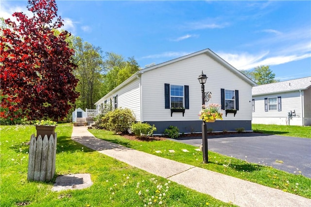 view of front of house featuring a front yard, a shed, and an outbuilding