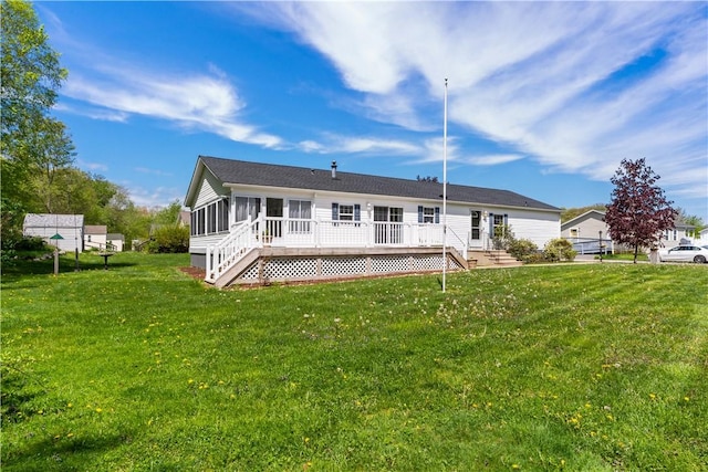 back of property featuring a sunroom, a yard, and a wooden deck
