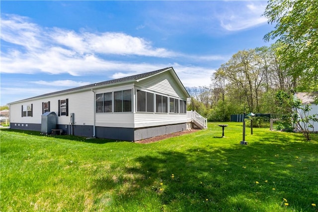 view of property exterior featuring a yard, stairs, and a sunroom