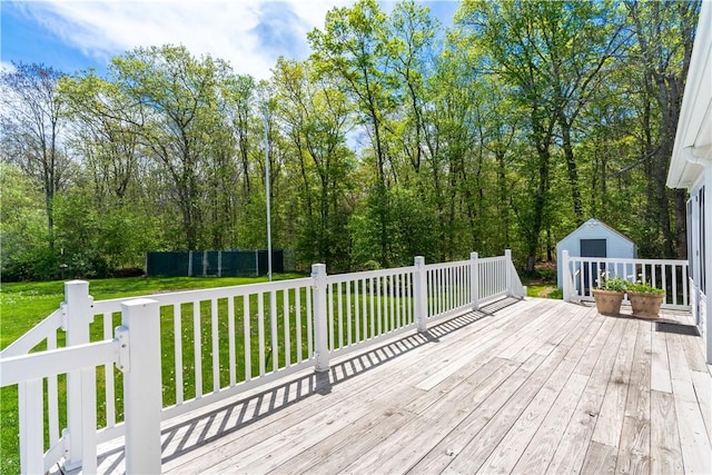 wooden deck featuring a yard, an outbuilding, and a shed