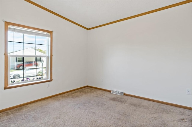 carpeted empty room featuring crown molding and baseboards