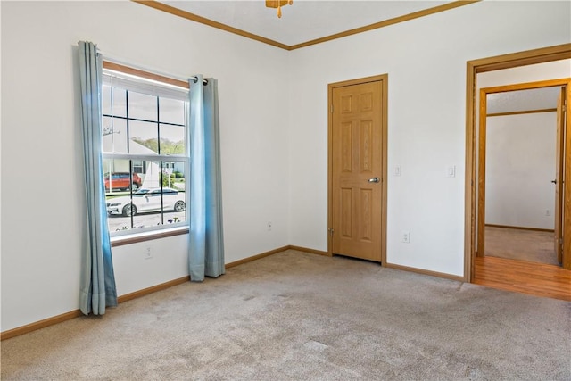 unfurnished room with carpet flooring, baseboards, and crown molding