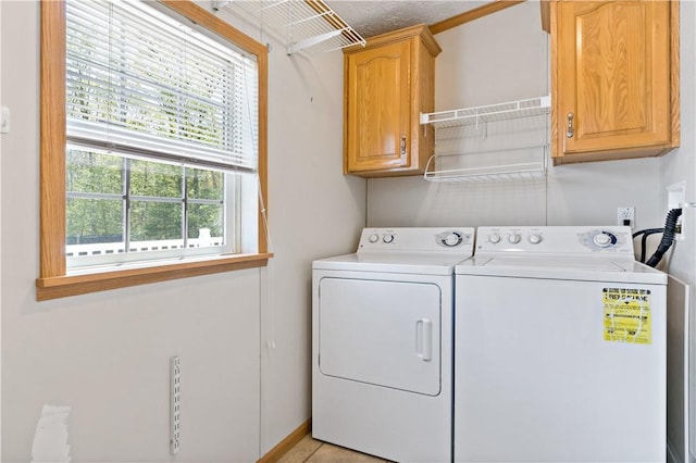 laundry area featuring cabinet space, independent washer and dryer, and baseboards