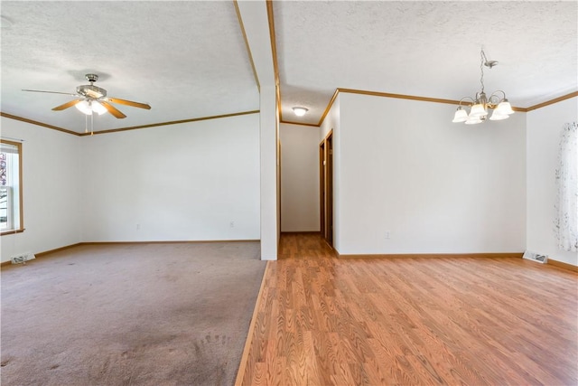unfurnished room with ornamental molding, a chandelier, baseboards, a textured ceiling, and ceiling fan