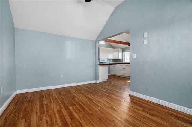1 Offshore Rd Unit 32, Narragansett, RI 02882 - unfurnished living room featuring lofted ceiling, wood finished floors, and baseboards