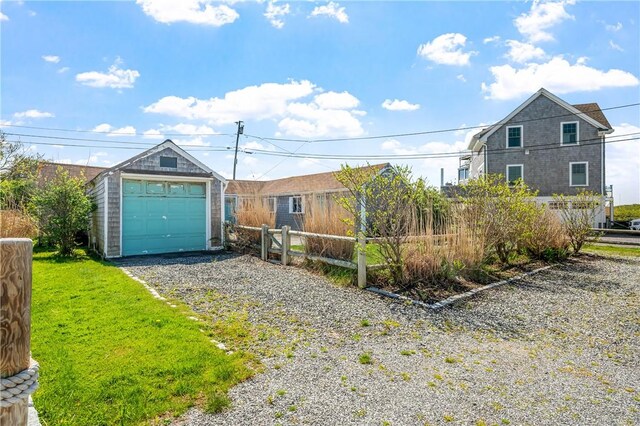 1 Offshore Rd Unit 32, Narragansett, RI 02882 - view of front facade featuring fence, an outbuilding, gravel driveway, and a garage