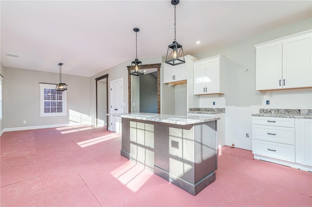 390 Lapham Farm Rd, Burrillville, RI 02859 - kitchen featuring white cabinets, hanging light fixtures, light stone countertops, a kitchen island, and baseboards