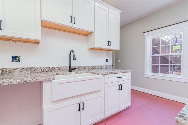 390 Lapham Farm Rd, Burrillville, RI 02859 - kitchen featuring a sink, white cabinetry, baseboards, and light stone countertops