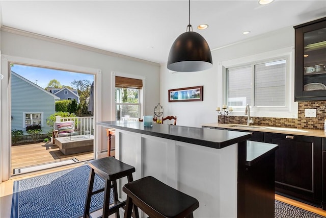 29 Webster St, Newport, RI 02840 - kitchen featuring a sink, a breakfast bar area, crown molding, recessed lighting, and glass insert cabinets