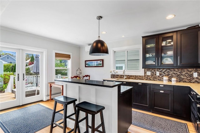 29 Webster St, Newport, RI 02840 - kitchen with a sink, a kitchen breakfast bar, crown molding, decorative backsplash, and baseboard heating