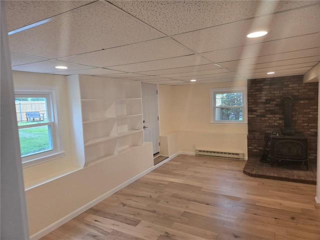 8 Centennial St, Coventry, RI 02816 - below grade area featuring baseboard heating, wood finished floors, a wood stove, baseboards, and recessed lighting