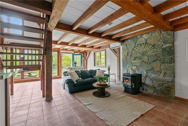 445 Plain Rd, West Greenwich, RI 02817 - living area featuring a wall unit AC, beam ceiling, tile patterned floors, a wood stove, and baseboards