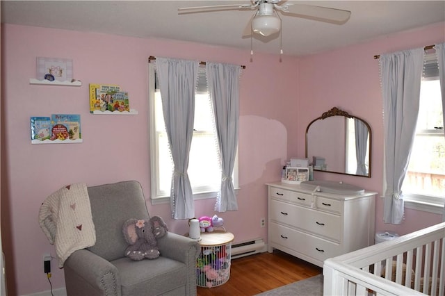 1 Watson Dr, Richmond, RI 02832 - bedroom with a nursery area, a baseboard heating unit, wood finished floors, and a ceiling fan