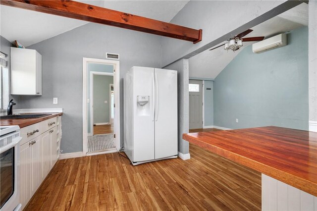 1 Offshore Rd, Narragansett, RI 02882 - kitchen with white refrigerator with ice dispenser, a sink, a wall unit AC, and light wood-style flooring