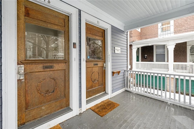 view of exterior entry featuring covered porch