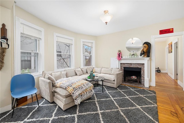 living room with wood finished floors, baseboards, and a tile fireplace
