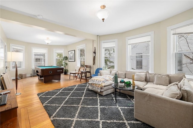 living area with healthy amount of natural light, pool table, wood finished floors, and radiator