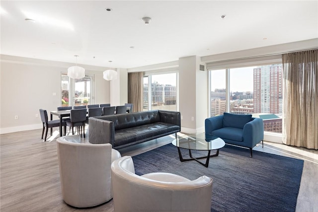 living area with baseboards, wood finished floors, and a view of city