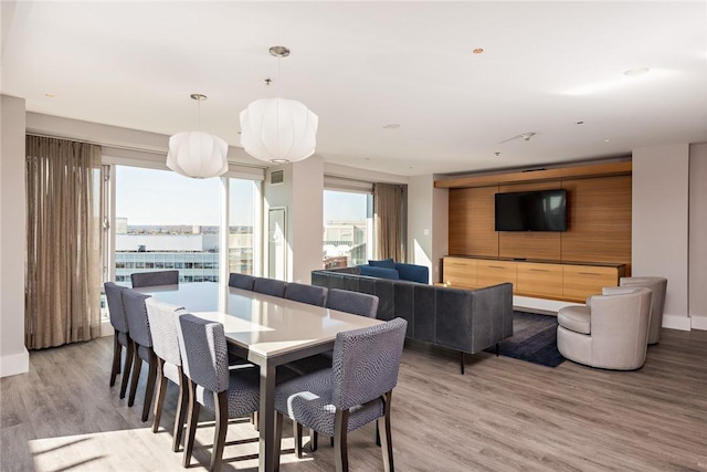 dining space featuring light wood-style flooring and baseboards