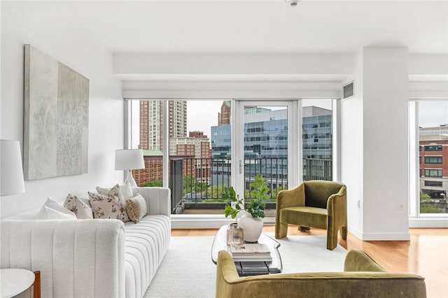 living room featuring wood finished floors, baseboards, and a city view